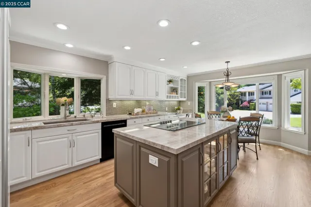 a kitchen with a stove a sink a dining table and chairs