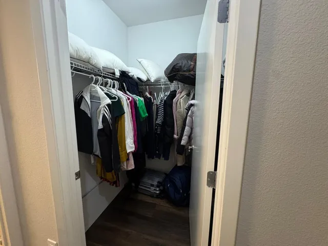 a view of walk in closet with clothes