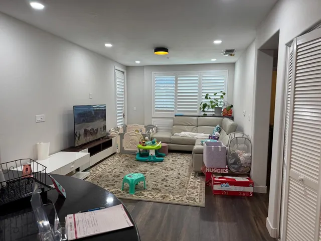 a living room with furniture and a flat screen tv with wooden floor
