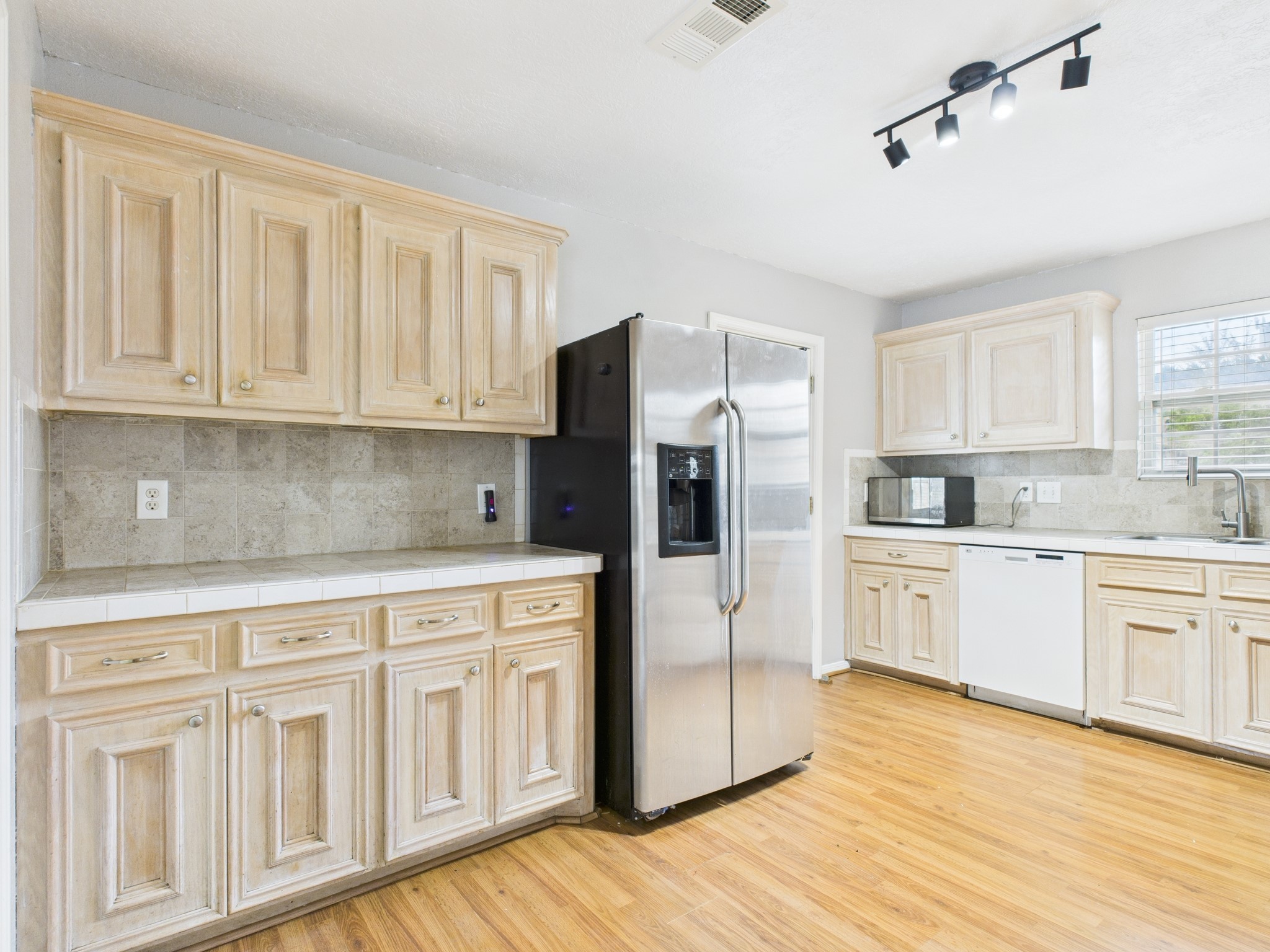 10130 Sussex Lane Houston, TX 77041 - Photo 10 of 20 a kitchen with stainless steel appliances granite countertop a refrigerator sink and white cabinets