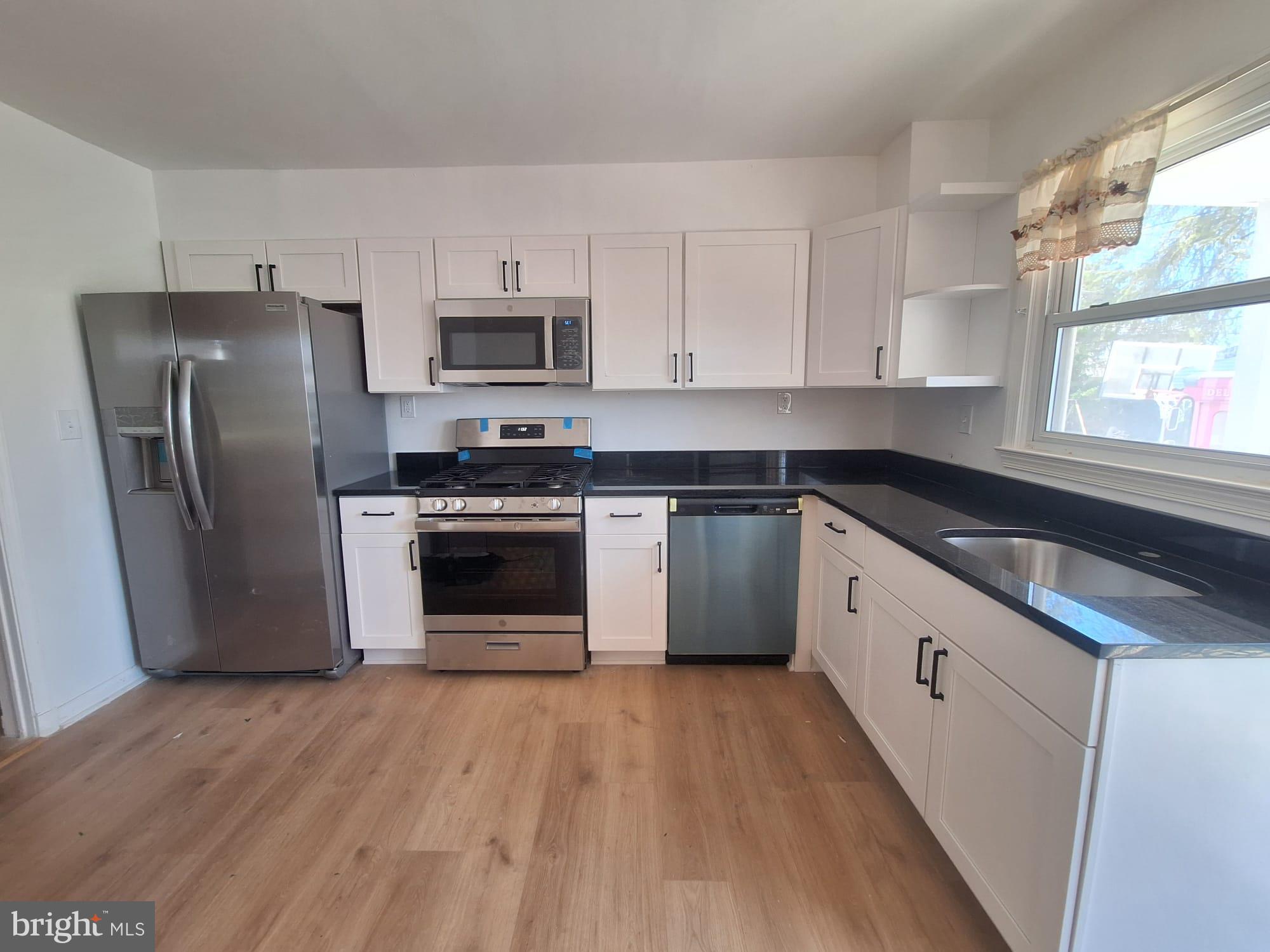 a kitchen with stainless steel appliances a stove a sink and a refrigerator