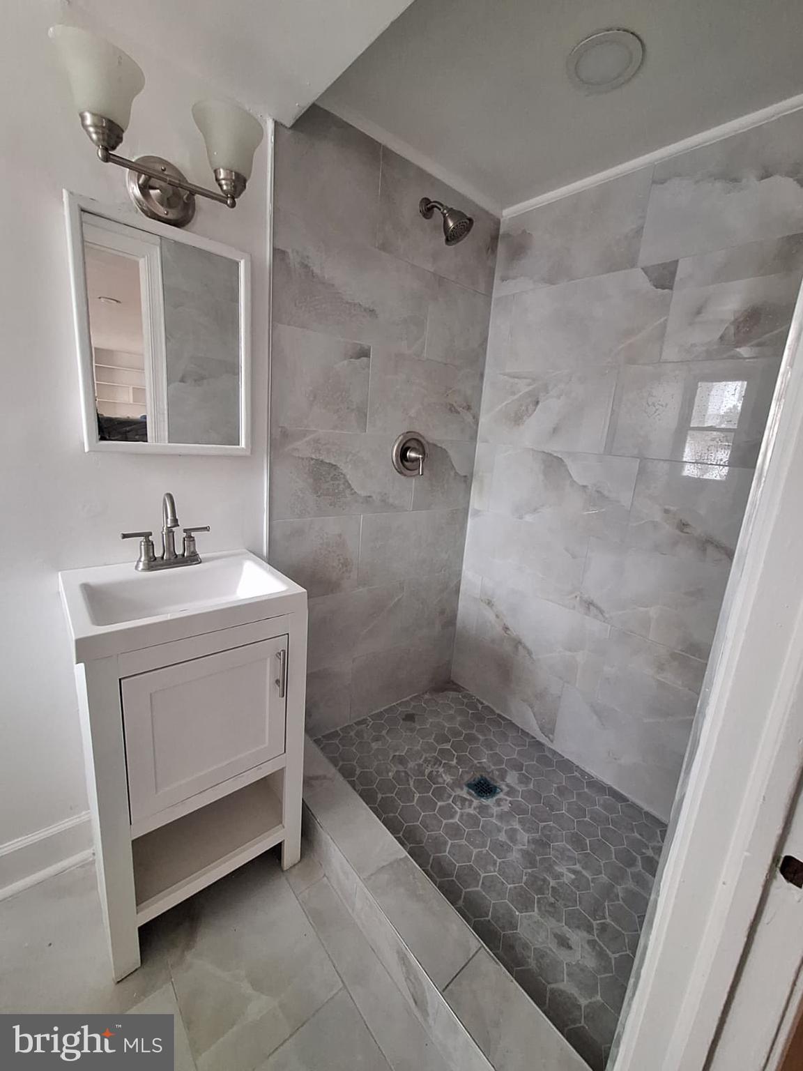 7910 Subet Road Baltimore, MD 21244 - Photo 3 of 8 a bathroom with a sink a mirror and a shower