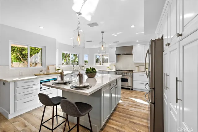 a large kitchen with kitchen island a large island in the center and stainless steel appliances