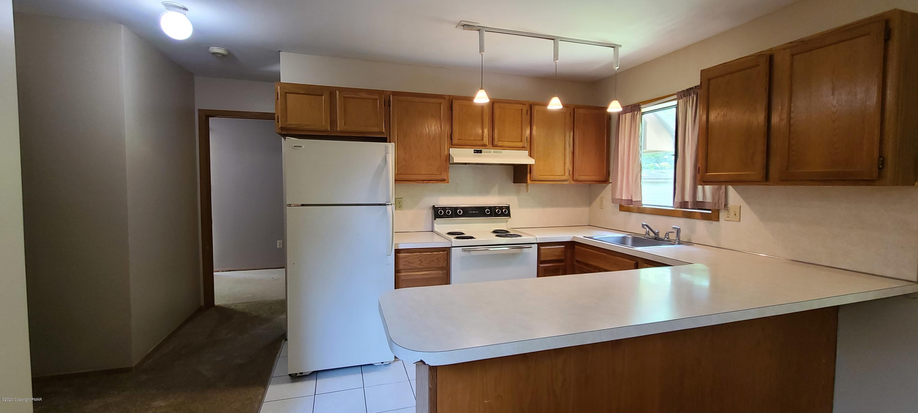 3359 Oberon Road Tobyhanna, PA 18466 - Photo 5 of 22 a kitchen with a refrigerator a sink and cabinets