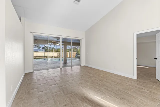 an empty room with floor to ceiling window and wooden floor