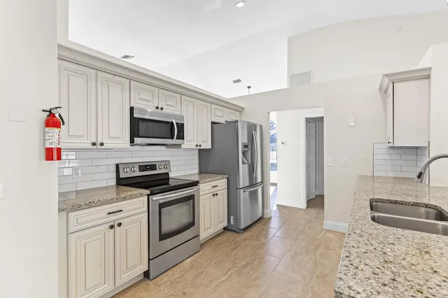 a kitchen with stainless steel appliances granite countertop a refrigerator sink and stove