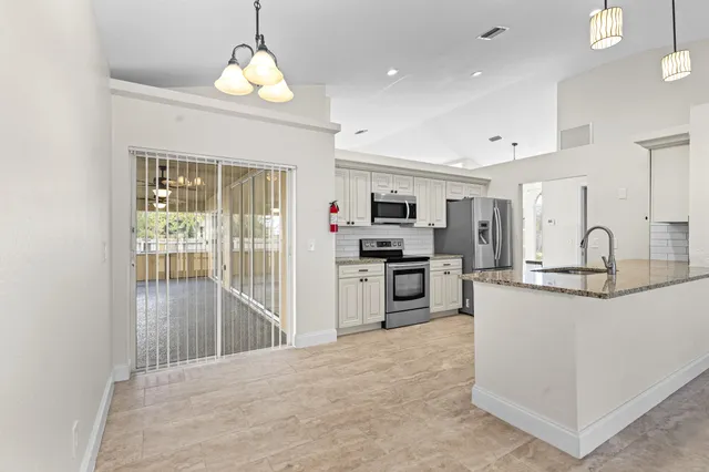 a kitchen with stainless steel appliances granite countertop a refrigerator and a stove