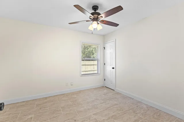 an empty room with a window and a fan