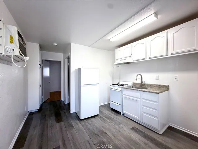 a kitchen with a sink a refrigerator and cabinets