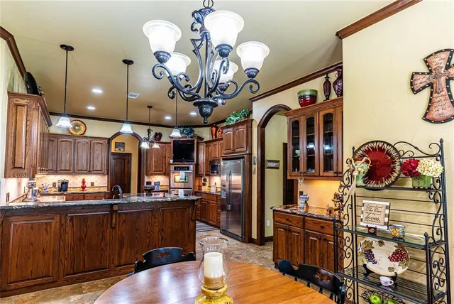 a kitchen with stainless steel appliances granite countertop a sink dishwasher and a black countertop with white walls