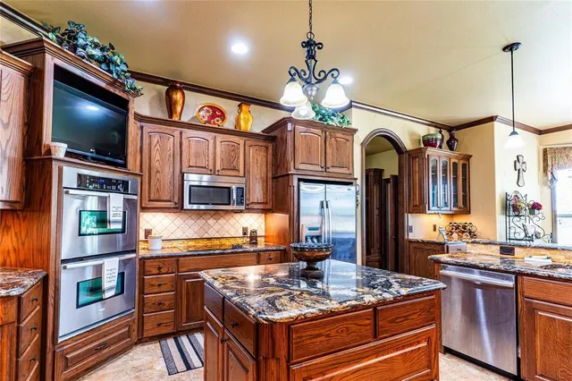 a kitchen with stainless steel appliances granite countertop a stove and cabinets