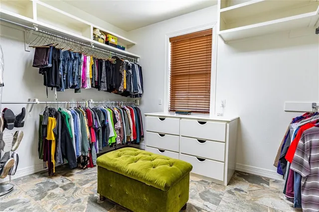 a view of walk in closet with clothes and shoes