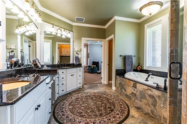 a large bathroom with a tub sink and mirror