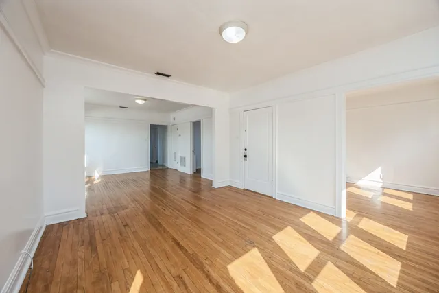 a big room with wooden floor and a bathroom