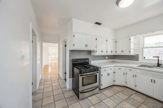 a kitchen with granite countertop white cabinets and appliances