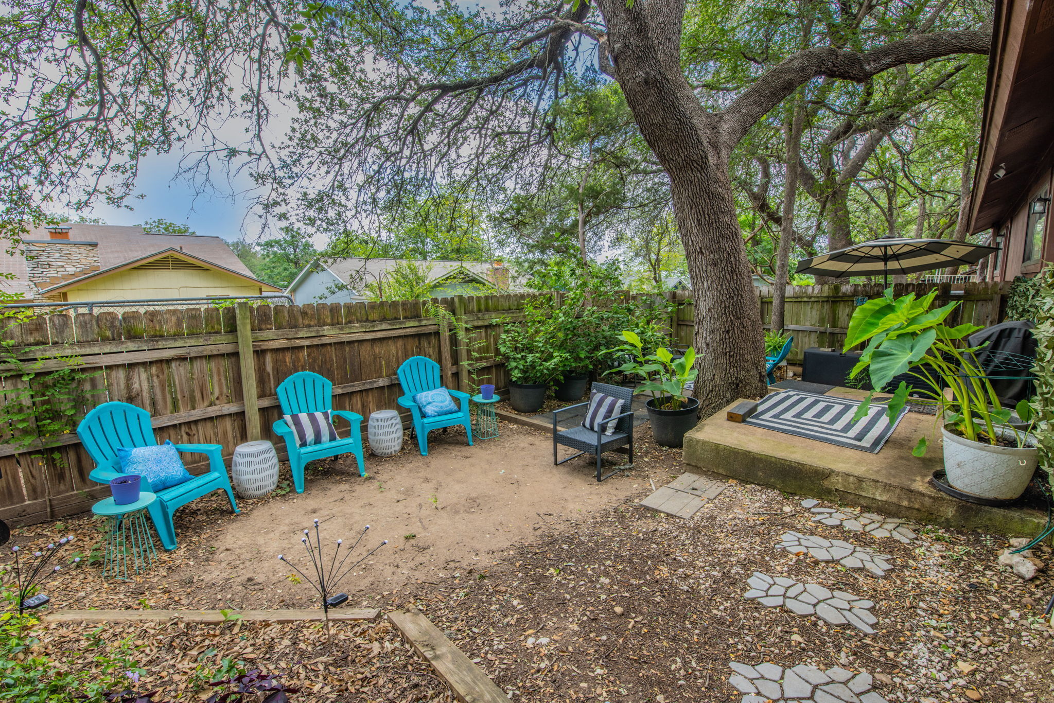 1008 Milford Way Austin, TX 78745 - Photo 17 of 40 Fenced backyard featuring mature trees, a concrete patio, and flagstone-style stepping stones