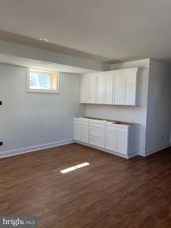 a view of a kitchen with wooden floor and a window