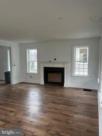 a view of empty room with wooden floor and fireplace