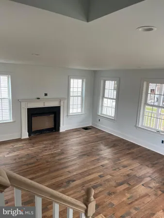 an empty room with windows and fireplace