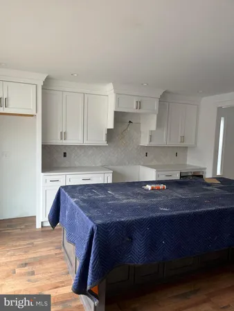 a kitchen with a wooden floor and cabinets