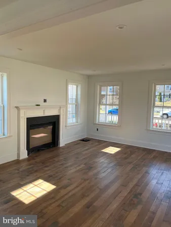 a view of empty room with wooden floor and fireplace