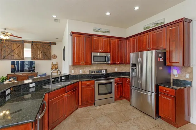 a kitchen with stainless steel appliances granite countertop a stove refrigerator sink and cabinets