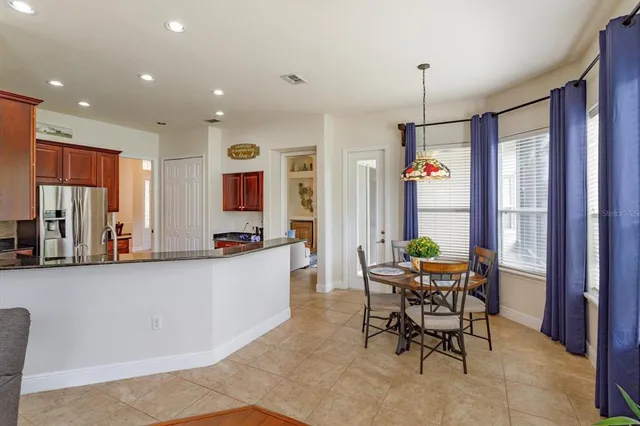 a view of a dining room and livingroom with furniture wooden floor a chandelier