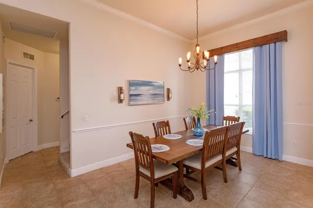 a dining room with furniture a chandelier and window
