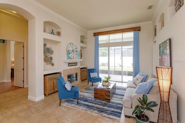 a living room with furniture fireplace and a large window