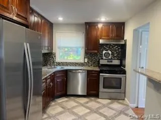 a kitchen with stainless steel appliances granite countertop a stove a refrigerator and a sink