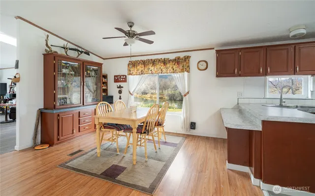 a dining room with wooden floor and white walls