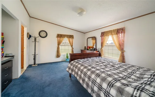 a bedroom with a bed and a dresser next to a window