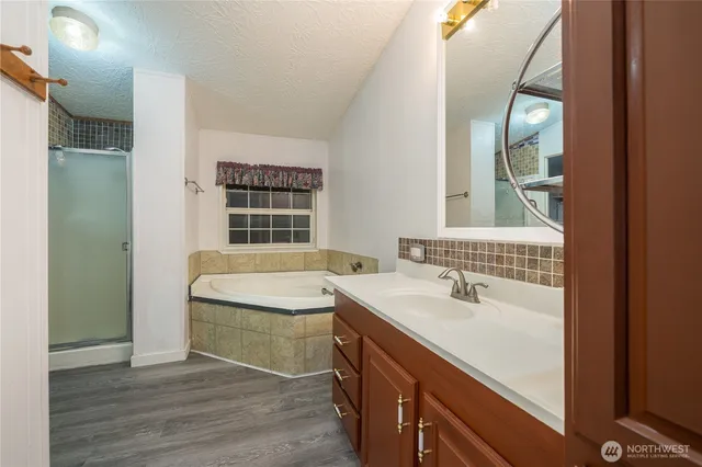 a bathroom with a tub sink and mirror