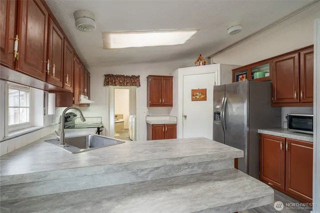 a kitchen with stainless steel appliances kitchen island granite countertop a refrigerator stove and oven