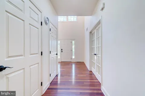 an empty room with wooden floor cabinet and windows