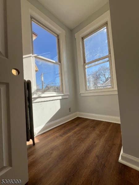 55 Schley Street Newark, NJ 07112 - Photo 5 of 8 a view of an empty room with wooden floor and a window