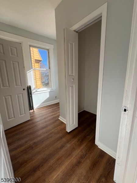 55 Schley Street Newark, NJ 07112 - Photo 6 of 8 an empty room with wooden floor and windows