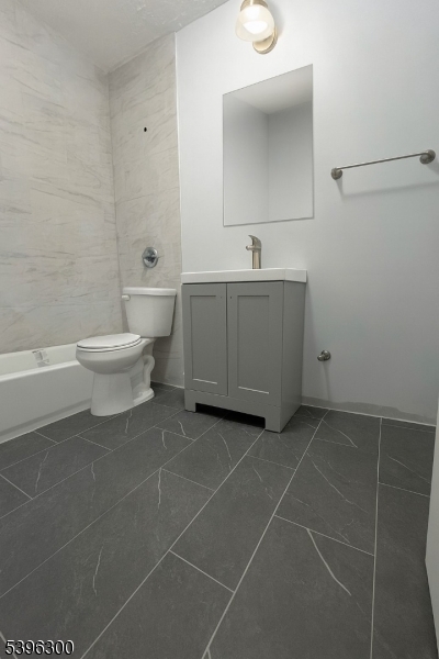 55 Schley Street Newark, NJ 07112 - Photo 8 of 8 a bathroom with a toilet sink and mirror