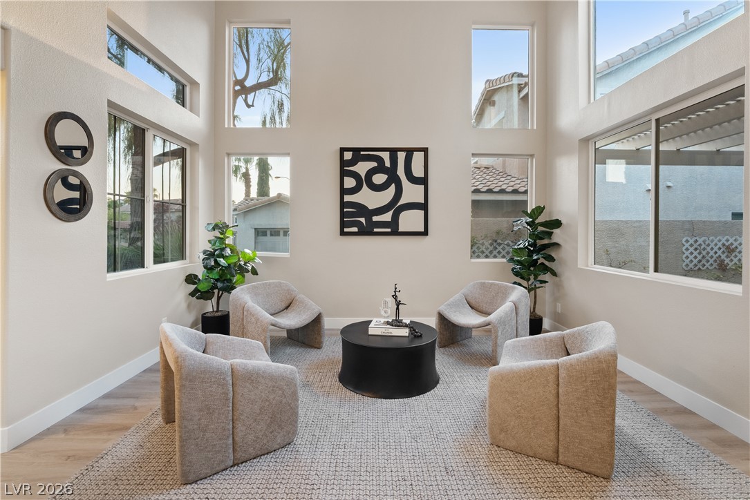 1662 Ravanusa Drive Henderson, NV 89052 - Photo 66 of 74 Natural light floods this inviting sitting area, featuring lofty ceilings and durable hardwood floors.