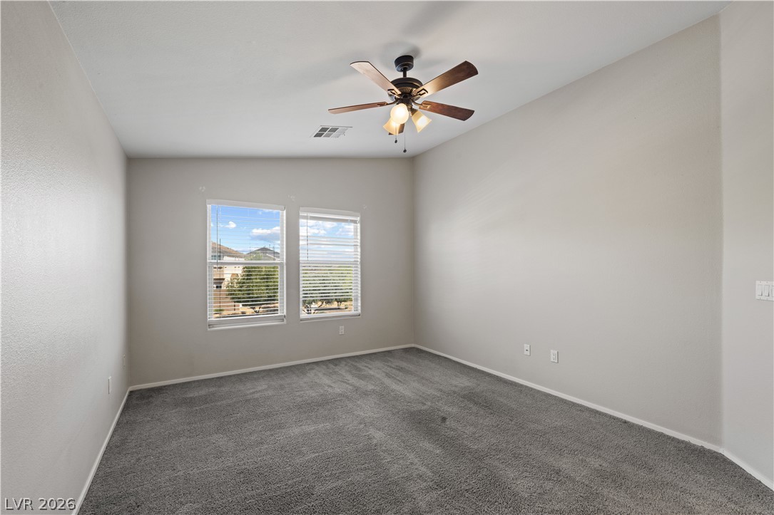 8777 Roping Rodeo Avenue, Unit 101 Las Vegas, NV 89178 - Photo 16 of 25 The carpeted bedroom features a ceiling fan and abundant natural light from dual windows.