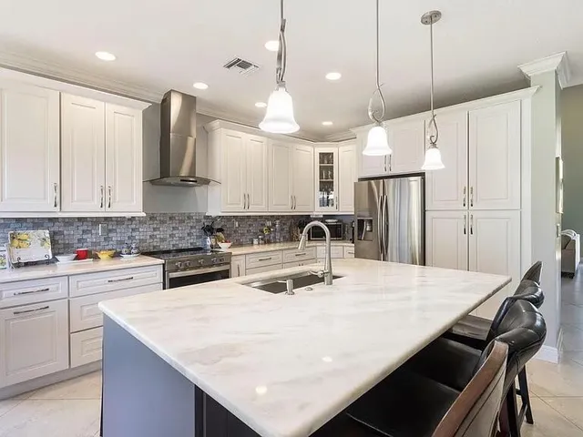 a kitchen with kitchen island a sink stove and refrigerator