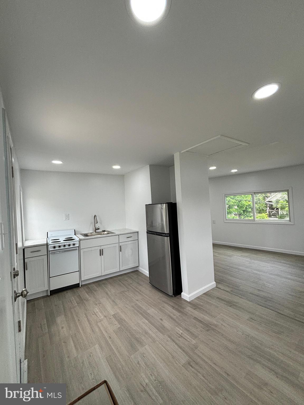 218 Elm Street Steelton, PA 17113 - Photo 20 of 22 a large kitchen with a wooden floor and a refrigerator