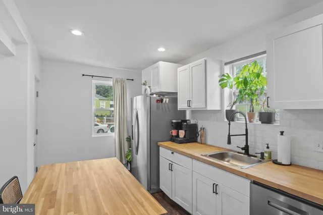 a kitchen with a refrigerator sink and cabinets