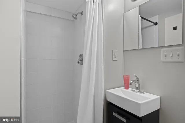 a bathroom with a sink a mirror and shower
