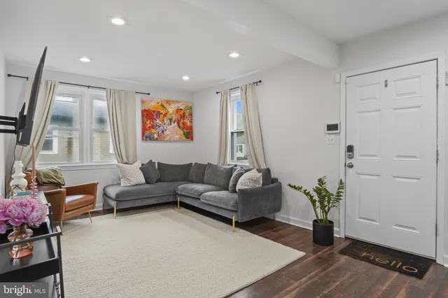 a living room with furniture flowerpot and wooden floor