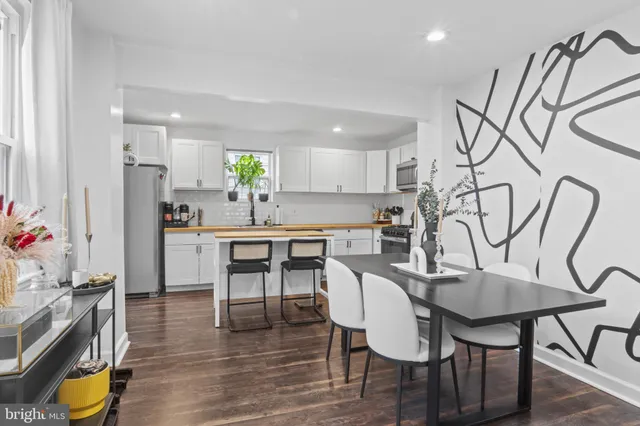 a kitchen with stainless steel appliances a dining table chairs and granite counter tops