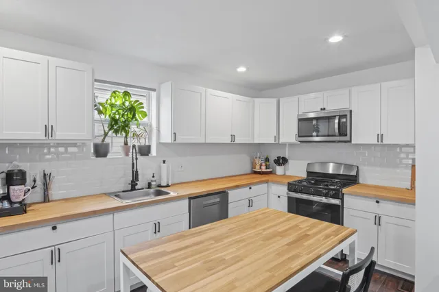 a kitchen with granite countertop a sink stove and cabinets