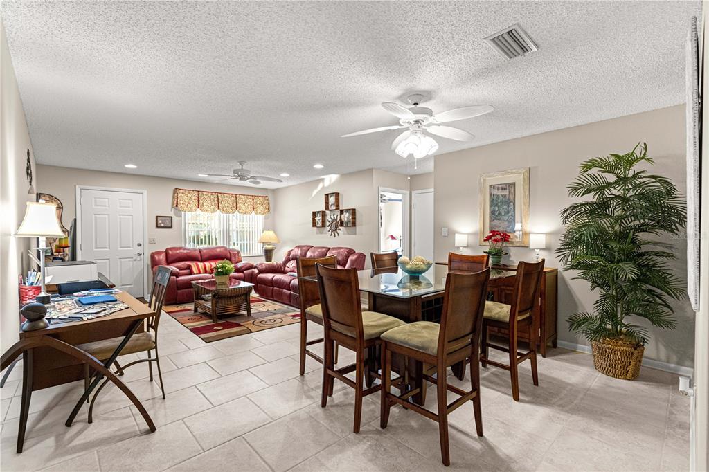 8431 Southwest 93rd Place, Unit G Ocala, FL 34481 - Photo 11 of 50 a view of a dining room and livingroom with furniture a rug a potted plant and a painting