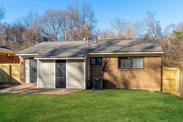 a view of a house with backyard and trees