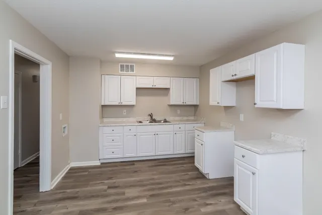 a kitchen with granite countertop white cabinets white stainless steel appliances with a sink and dishwasher